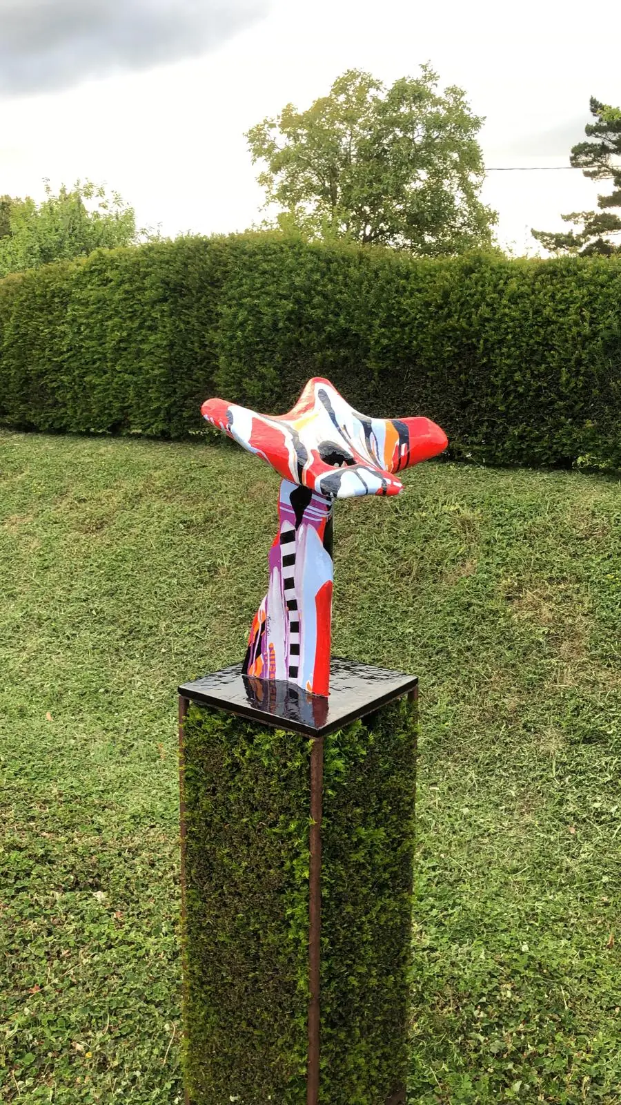 Zeitgenössisches Kunstwerk auf der Hecke der grünen Galerie